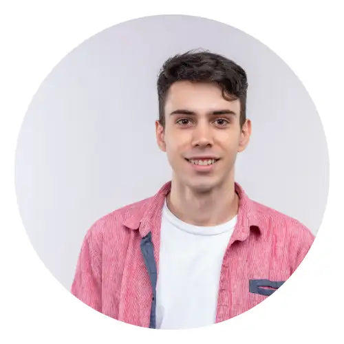 En ung mand iført en lyserød tekstureret knapop-skjorte over en hvid t-shirt.